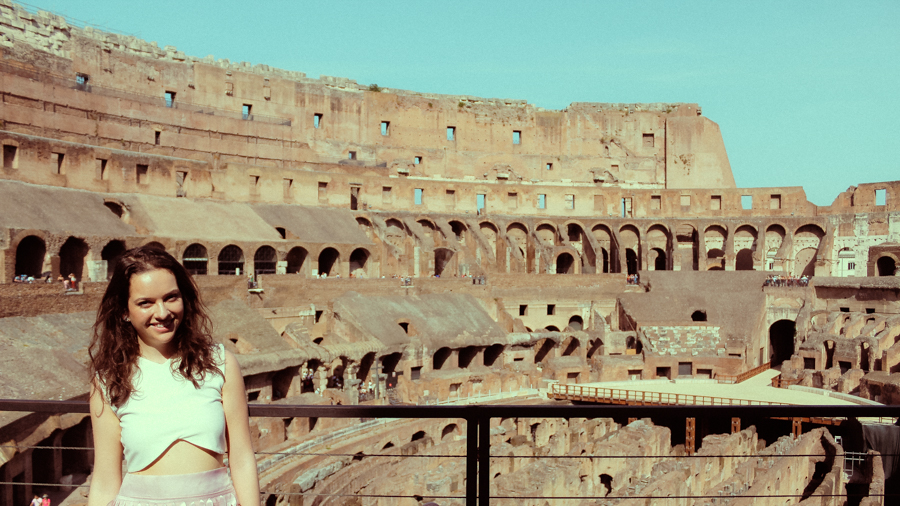 Menina sorrindo para foto, dentro do Coliseu em Roma, Itália